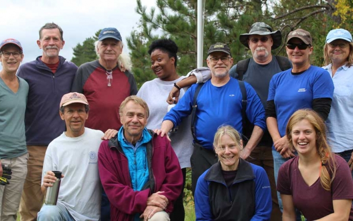 A group of people pose for a group photo during a service project with Outward Bound.